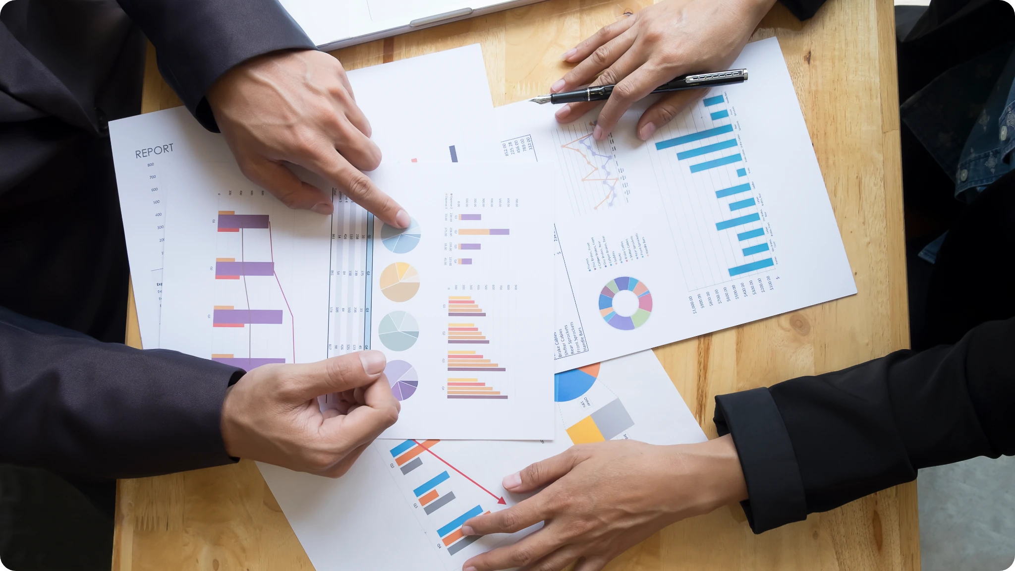 two people discussing and marking on paper file on the table